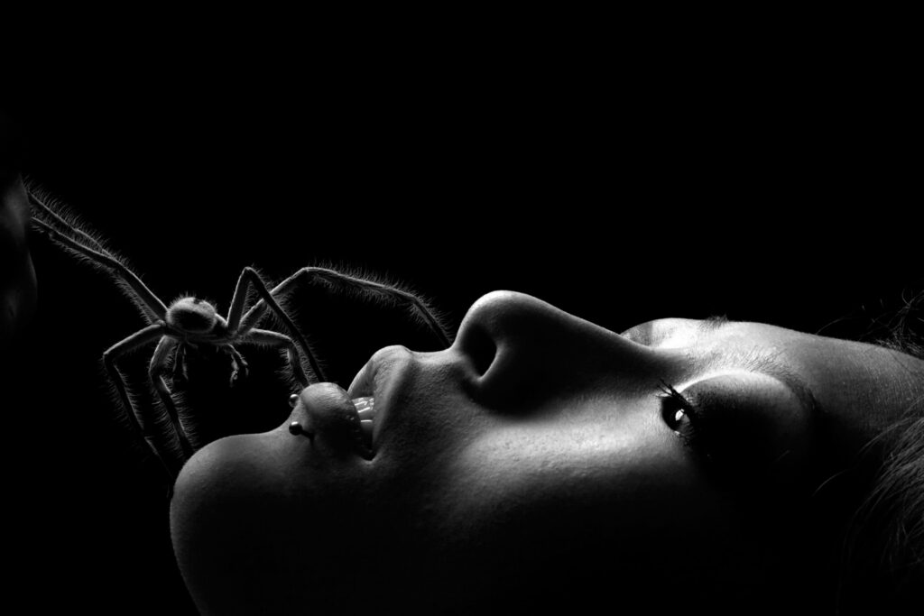 A spider crawls on a woman's face.